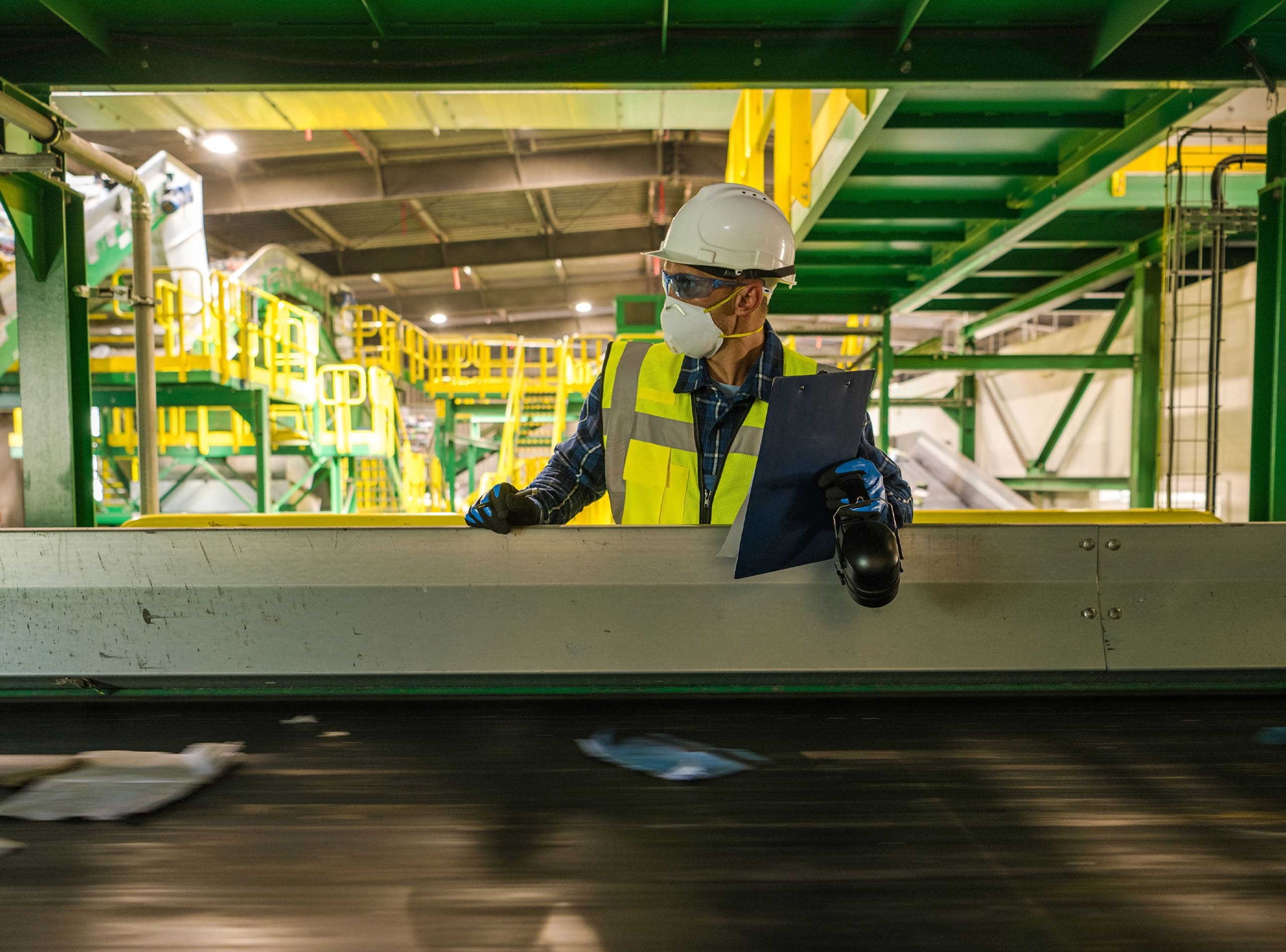 Waste Pro Case Study Hero - Waste Management Worker Checking on Running Trash Material on Conveyor